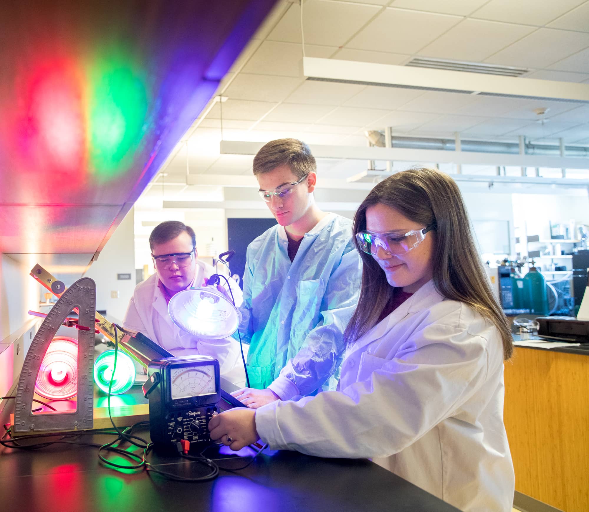 People in a lab working with colored light