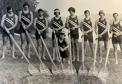 The 1975 varsity crew (from L to R) Steve Loomer (stroke), Mike Melvin, John Hill, John Moynihan, Dick Suess, Bill Fitzpatrick, Paul Gowen, Peter Berg (bow) and kneeling Rich Berg (cox).