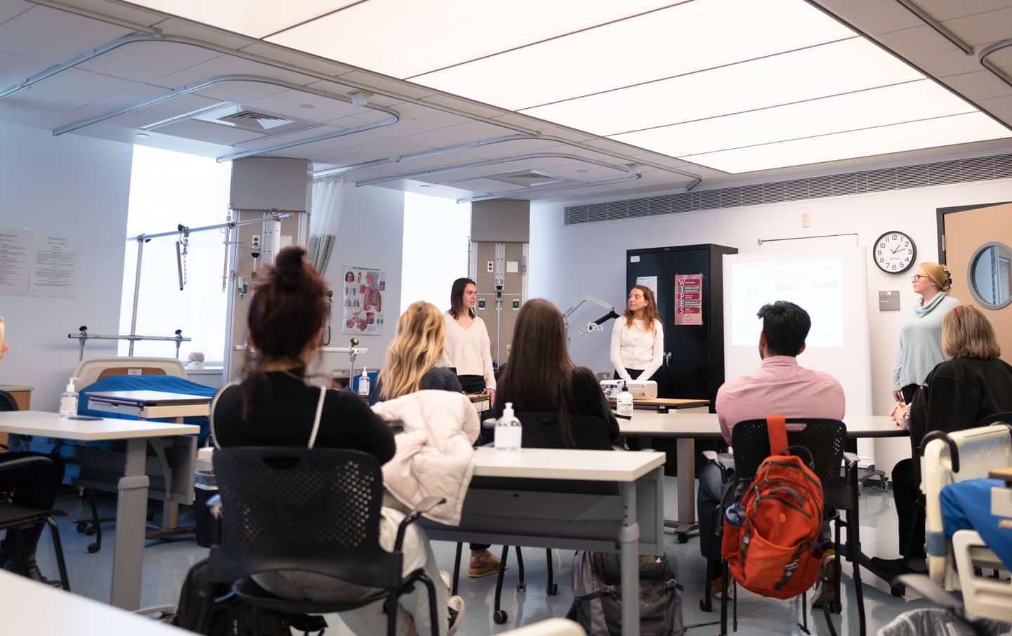 Students listening to instructors in nursing classroom